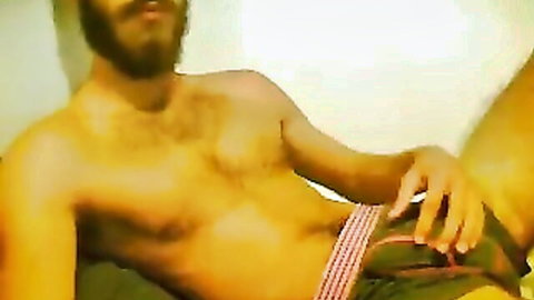 Scruffy bearded man poses shirtless in striped underwear showing off muscular body
