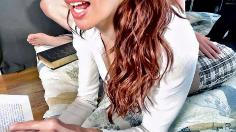 Redhead babe in white blouse and plaid skirt reads book as man's hand grips her thigh on bed