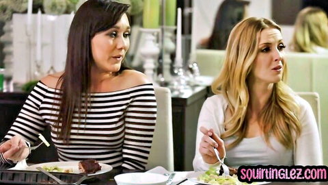 Brunette and blonde lesbians dining intimately at restaurant table