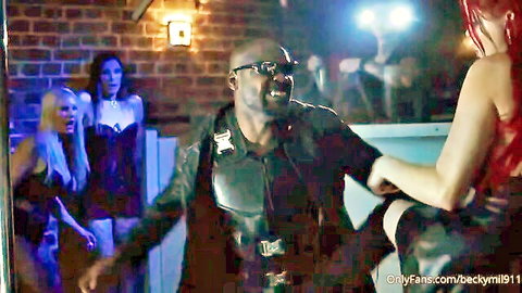 Busty redhead with huge tits grabbed on thigh by black stud in leather jacket in neon club