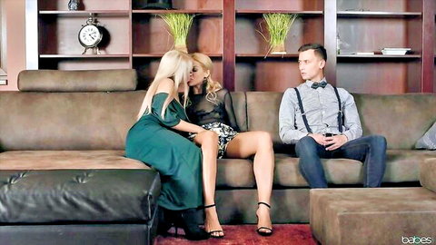 Two sexy blondes in sheer top and mini dress flirt intimately with handsome guy on leather couch