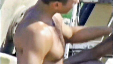 Muscular shirtless gay hunk leaning into car door showing ripped back and shoulders