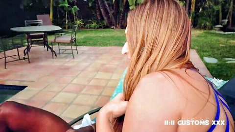 Skylar Snow in blue bikini lounging poolside, redhead curves