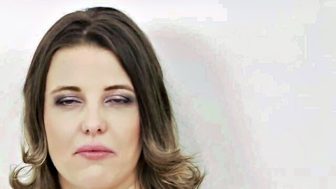 Sultry brunette woman with smoky eyes and glossy pouty lips looking seductive.