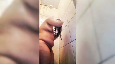 Chubby hand pinching wet black pubic hair against steamy shower tiles