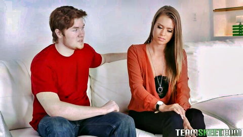 Blonde babe and redhead guy sitting close on sofa in teasing chat