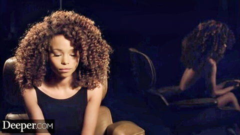 Cecilia Lion ebony beauty with curly hair in seductive seated pose