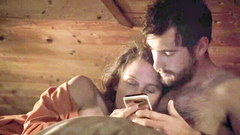 Manue Fleytoux topless cuddling bearded man in bed, nude tits scene from The Deadman's Bride (2022)