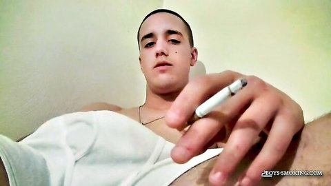 Muscular young guy holds lit cigarette close-up POV in white tank top showing toned chest