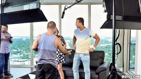 Gia Paige in short dress on adult video set with crew, tempting teen scene setup