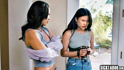 Two petite Asian babes in tight tank tops showing cleavage tease at doorway