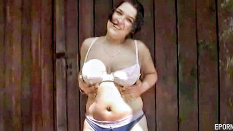 Curvy BBW with large breasts exposing tits outdoors in white bra and blue panties