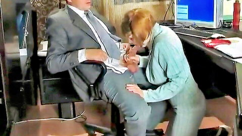 Redhead giving blowjob to suited man in office job interview