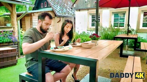 Bearded man and brunette woman eating outdoors in Daddy4K risky sex scene