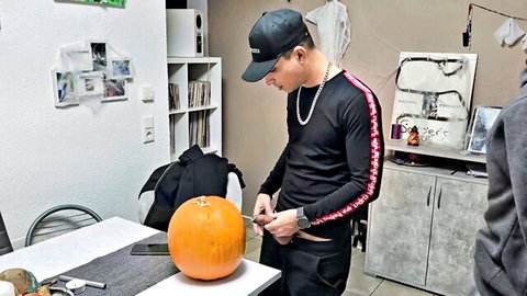 Matteo Martini carving pumpkin with friend in Halloween gay setup