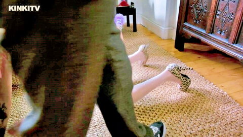 Petgirl April on floor with legs spread in pink and leopard heels during kink interview