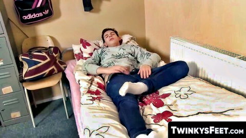 Young twink Jason Ward relaxing on bed in socks, teasing feet solo