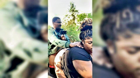 Curvy black woman bent over in nature, partner filming from behind