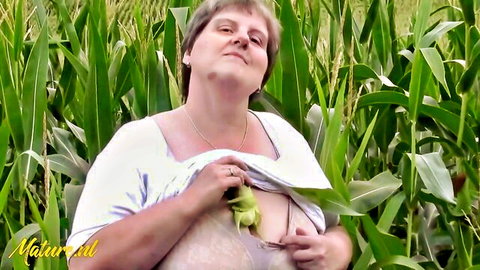 Curvy blonde mature woman flashing big tits in cornfield with corn cob