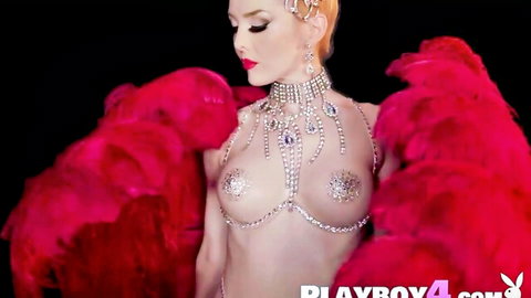 Glamorous redhead babe with sparkling jeweled pasties on perky tits and red feather boa posing seductively