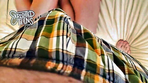 POV closeup under plaid shirt of teen girl's bare legs and feet on bed