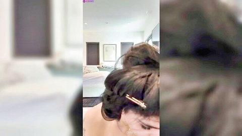 Mia Khalifa in casual livestream pose with hair in bun, bare shoulder