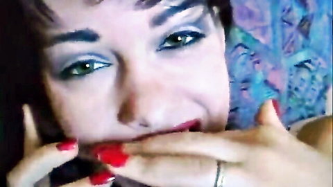 Seductive close-up of woman with green eyes, red lips and nails