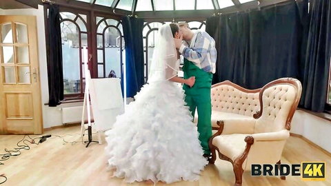 Stranger in green suit passionately kissing bride's neck in fluffy white wedding dress