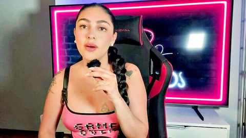 Busty Latina with braided hair in pink tank top explains masturbation reasons, teasing cleavage