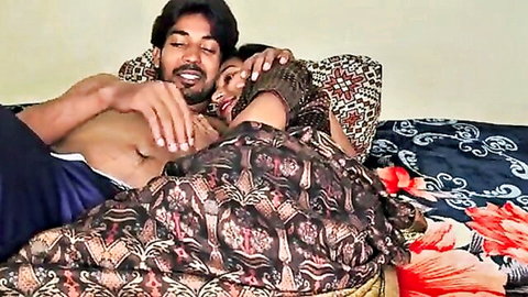 Desi couple in intimate embrace, woman in patterned saree hugged by bare-chested man