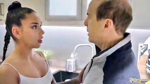 Young brunette with huge tits in tank top flirts closely with bald old man by kitchen sink