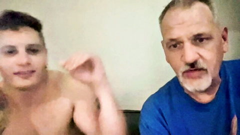 Shirtless muscular twink smiling with bearded daddy on amateur webcam