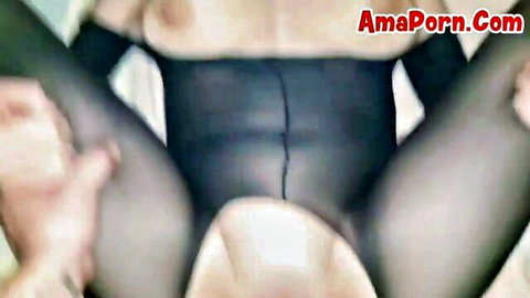 Brunette MILF spreads legs in sheer black pantyhose as hand rubs her visible pussy lips