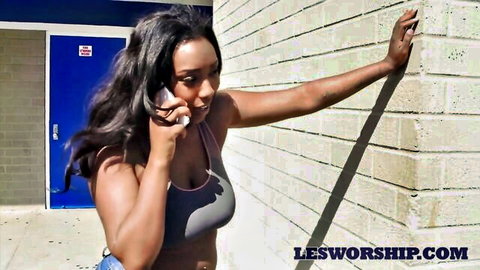 Curvy black babe in tight sports bra and shorts talking sexy on phone outdoors