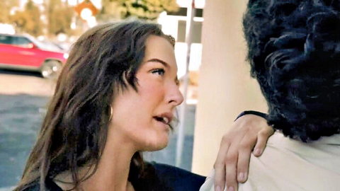 Brunette woman grips black man's shoulder intimately in outdoor parking lot tease