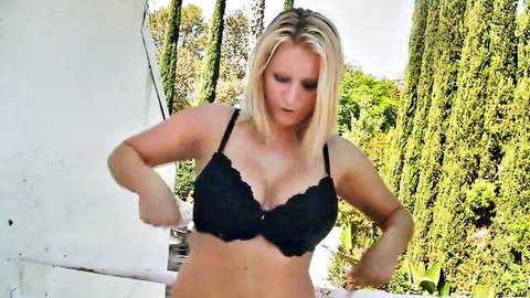 Blonde babe with big natural tits in black lace bra teasing cleavage outdoors