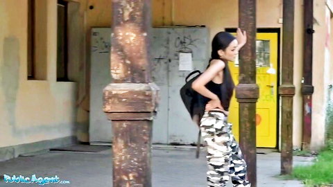 Young skinny Asian babe with long hair teases small tits in tight black tank top and camo pants outdoors