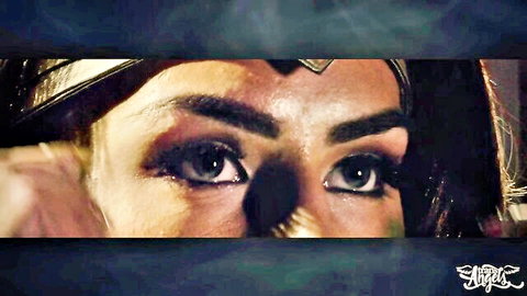 Close-up of seductive Wonder Woman cosplay babe with blue eyes applying heavy smoky eyeliner