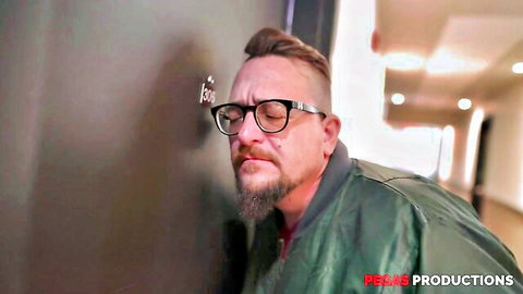 Bearded man in glasses and green jacket teases in hallway for tempting MILF xxx scene