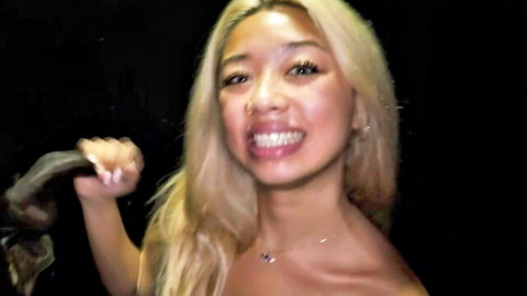 Bella Blond smiling topless holding black dildo