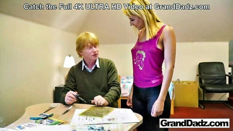Young blonde teen stands over older redhead man in casual attire