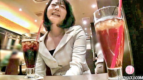 Smiling Japanese MILF in white blazer at table with cola and iced tea drinks