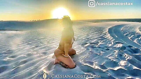 Cassiana Costa kneeling in bikini on sunny desert dunes at sunset