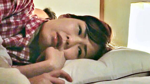 Seductive Japanese wife in intimate bed pose, thoughtful expression