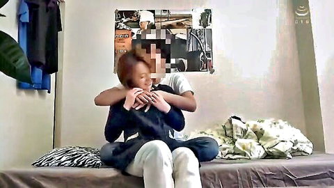 Intimate Asian couple hugging on bed in casual clothes