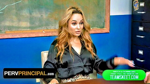 Busty pervy principal in shiny black blouse showing deep cleavage at classroom desk
