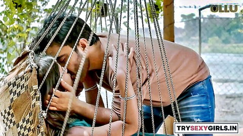 Indian couple sharing passionate kiss on swing in Ullu series