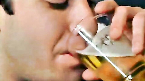 Closeup of man sipping foamy beer from glass wetting his lips
