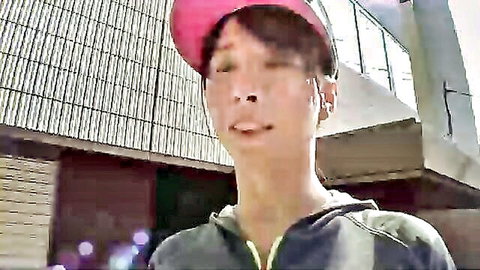 Asian model in pink cap and grey hoodie, outdoor urban setting
