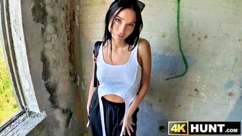 Milena Ray as hitchhiker posing in ruins, white crop top and black pants